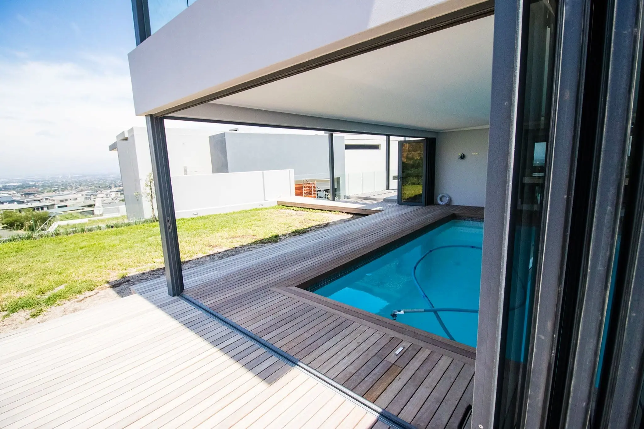 View through the open aluminium system towards the pool and Cape Town