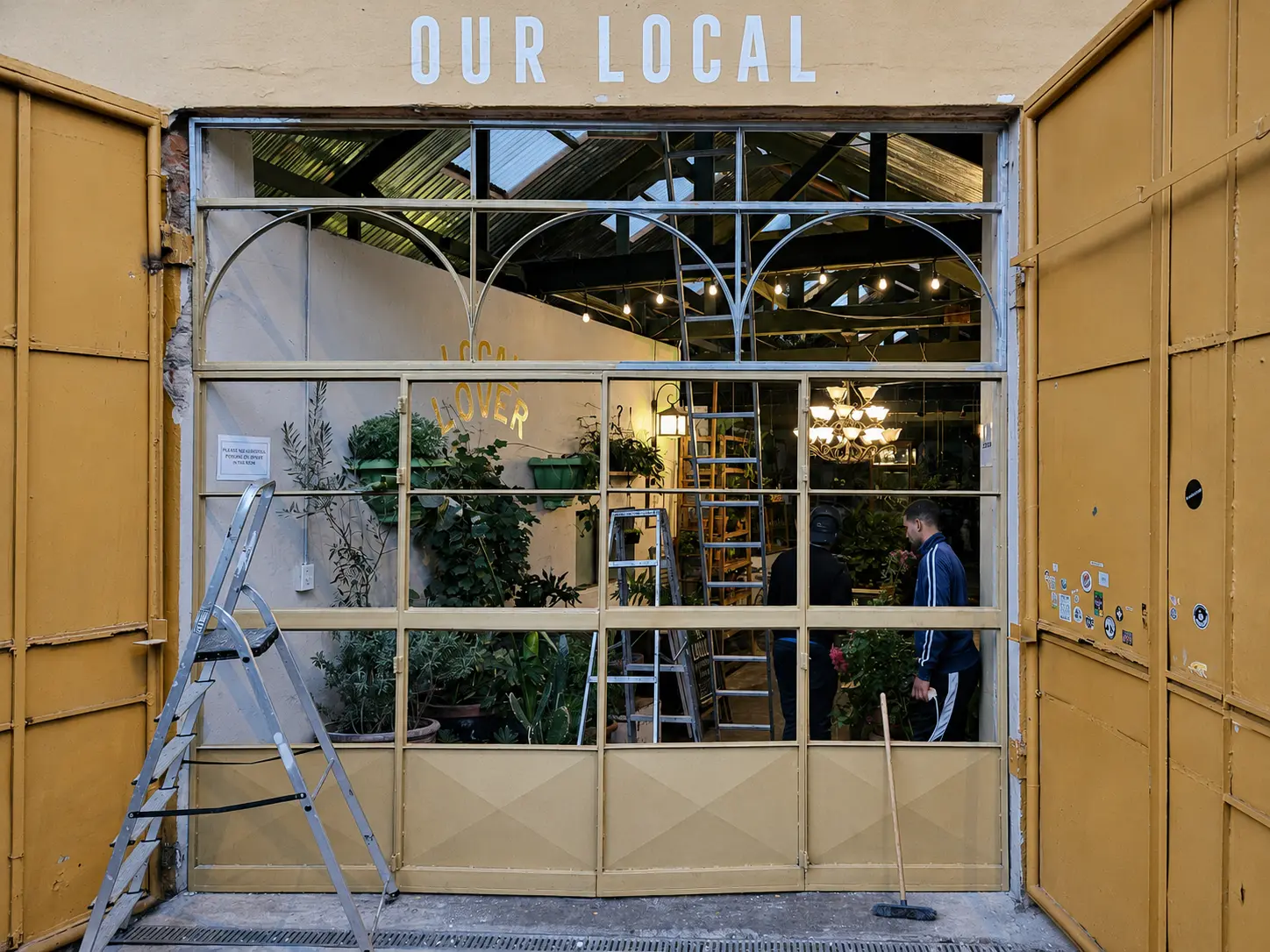 Close view of the galvanised arched steel shopfront during installation at Our Local