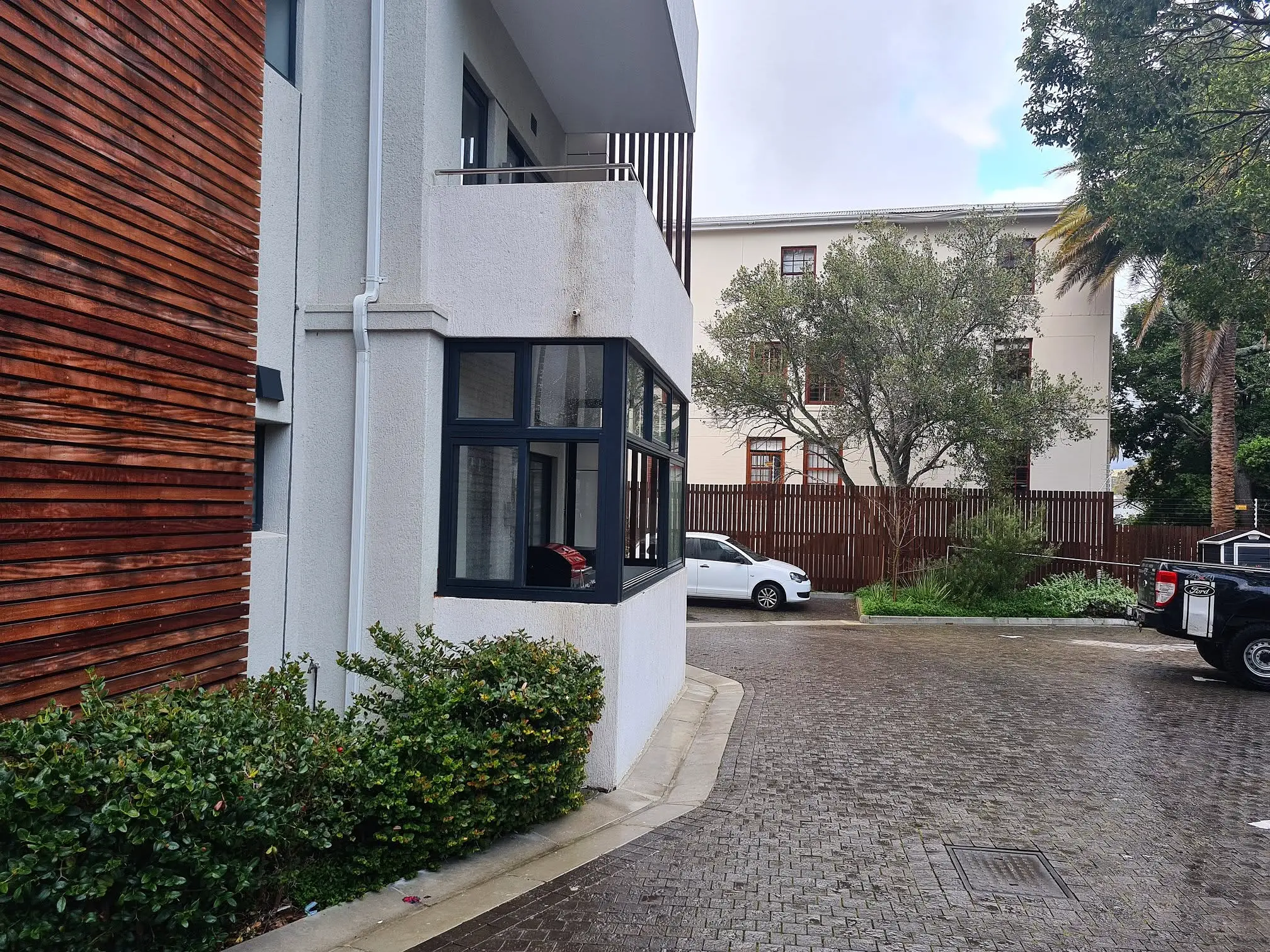 Wider courtyard view of the completed Plumstead balcony enclosure